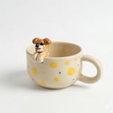 Polka-dot ceramic mug with a small dog figurine placed inside the cup.
